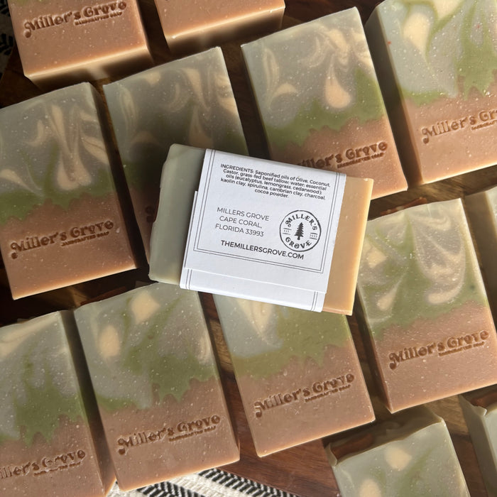 Multiple bars of Miller's Grove soap with a central bar displaying the brand label.