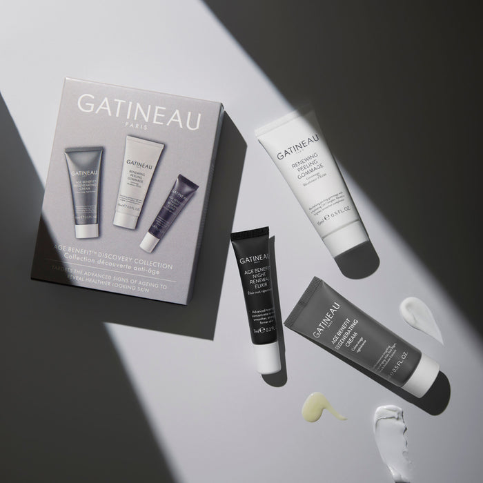 Age Benefit Discovery Collection box, Age Benefit Night Renewal Elixir, Age Benefit Regenerating Cream and Renewing Peeling gommage laid on a surface with product textures