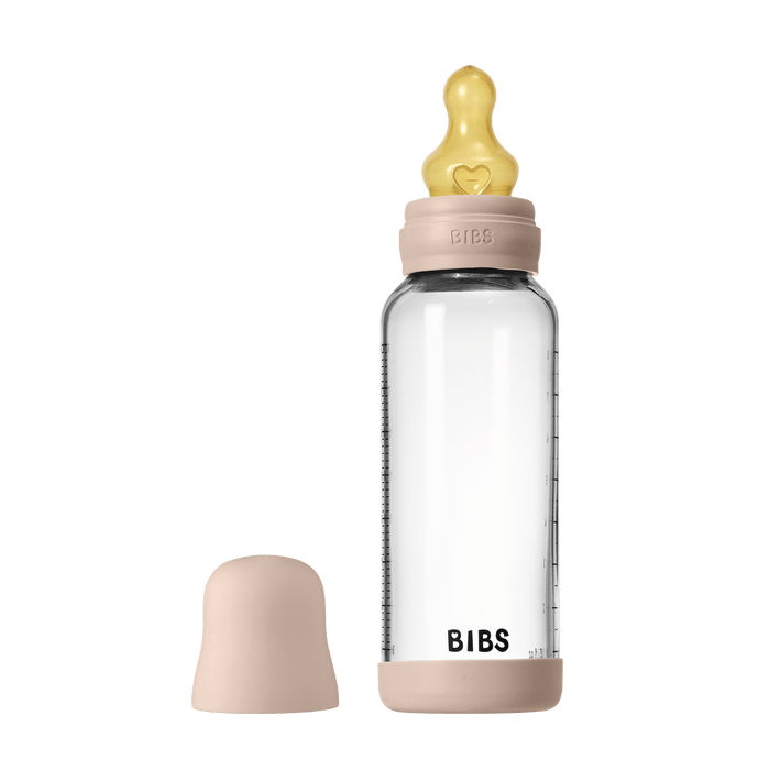 BIBS Glass Baby Bottle 240ml in blush with yellow latex teat and cap beside it, on white background