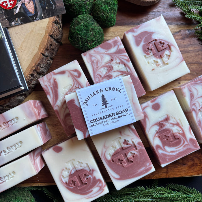Handmade soap bars with a brand label on a wooden board with greenery