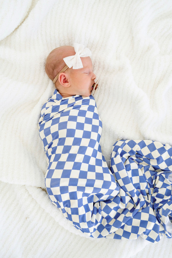 jett swaddle blanket newborn girl with tulle bow swaddled on bed