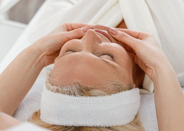 Person receiving a facial treatment with a white towel on their face.