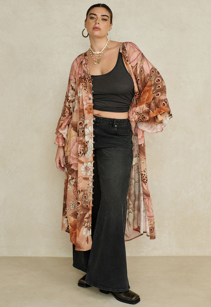 Model wearing Stealing Beauty Gown open over black crop top and maxi skirt, front button detail visible